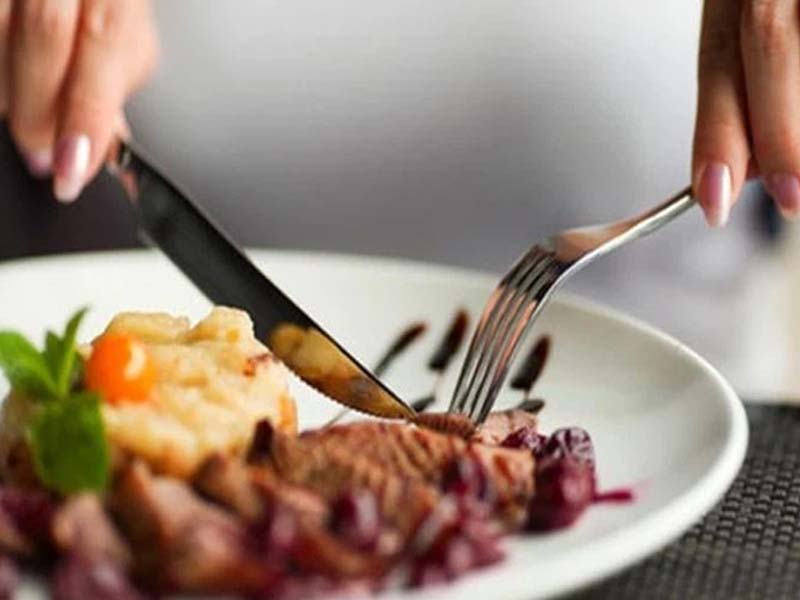 Nĩa luôn ở bên tay trái và úp xuống để cố định thức ăn